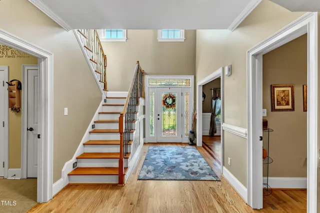 a view of a hallway with wooden floor and living room