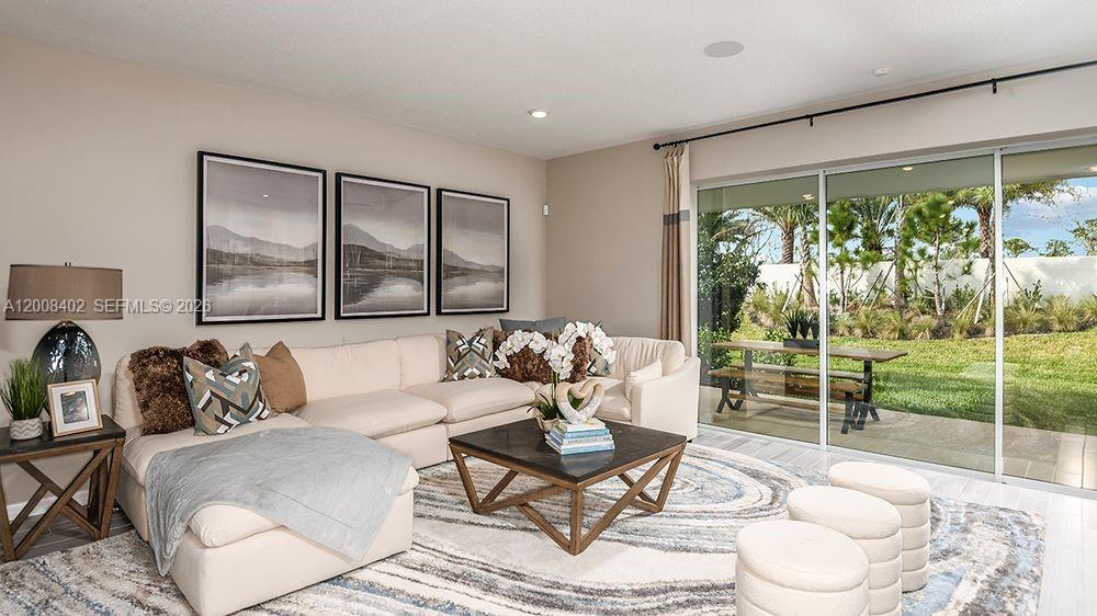 657 Southeast Ranch Oak Circle Port St. Lucie, FL 34984 - Photo 12 of 43 a living room with furniture and a large window