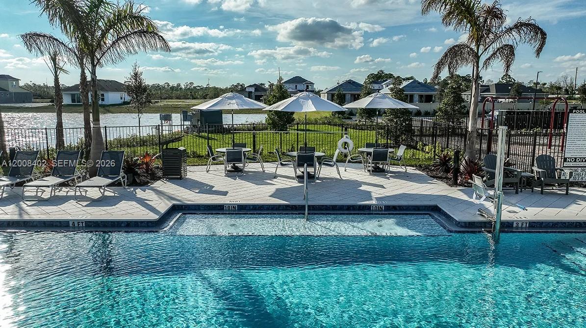 657 Southeast Ranch Oak Circle Port St. Lucie, FL 34984 - Photo 41 of 43 a view of a patio with table and chairs potted plants and palm tree