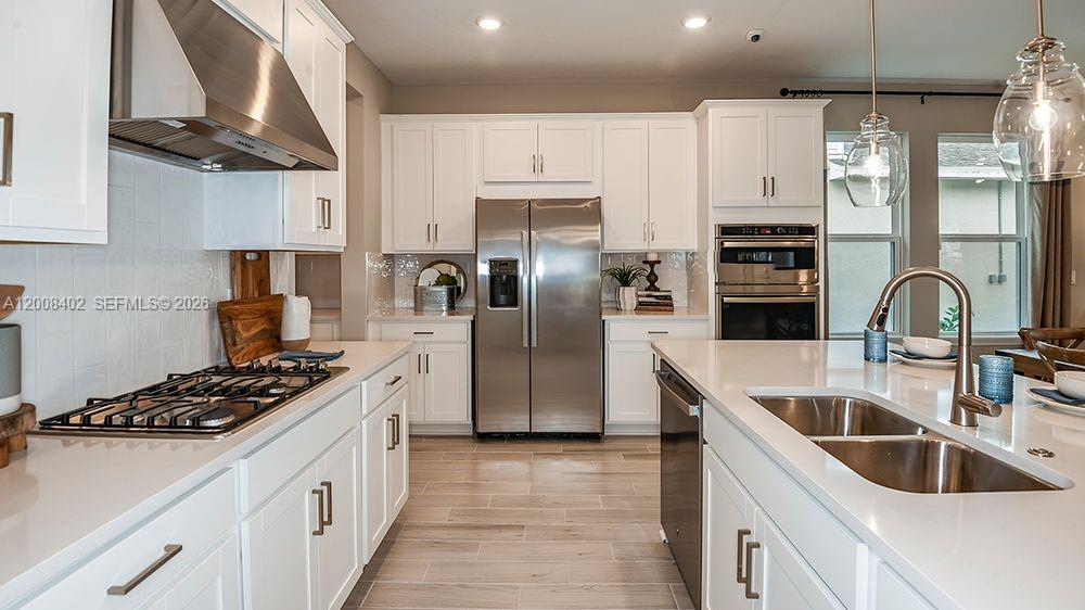 657 Southeast Ranch Oak Circle Port St. Lucie, FL 34984 - Photo 8 of 43 a kitchen with stainless steel appliances granite countertop a sink stove and refrigerator