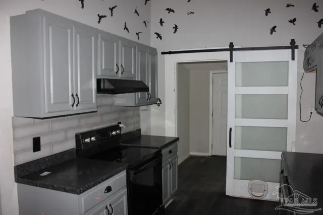 a kitchen with granite countertop a stove and a refrigerator