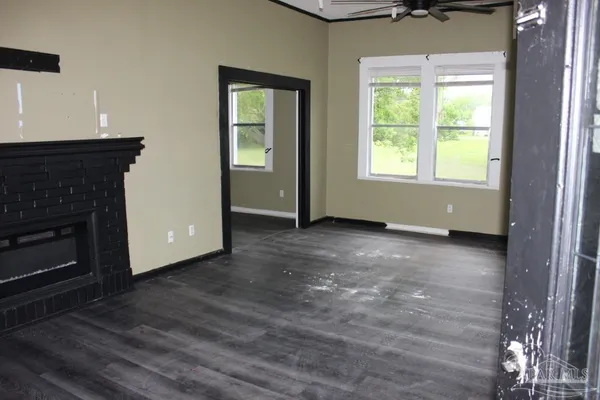 an empty room with windows and fireplace