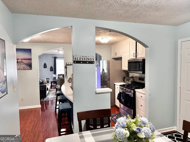 a living room with furniture a flat screen tv and a dining table
