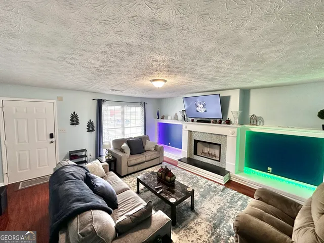 a living room with furniture a flat screen tv and a fireplace
