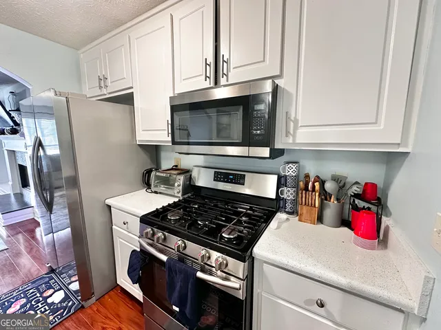 a kitchen with stainless steel appliances granite countertop a stove and a microwave