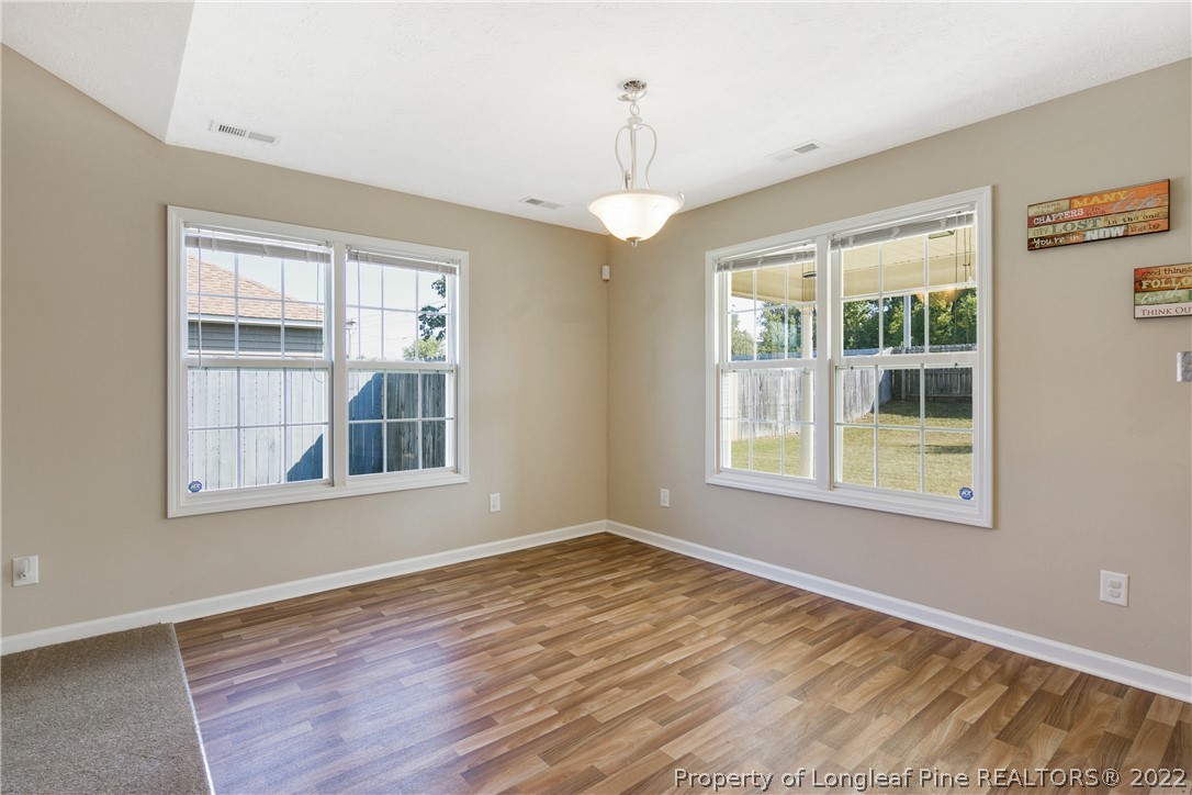 654 Hogart Street Raeford, NC 28376 - Photo 11 of 35 a view of an empty room with wooden floor and a window