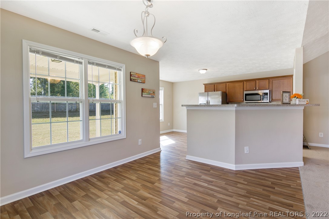 654 Hogart Street Raeford, NC 28376 - Photo 12 of 35 a view of a kitchen with wooden floor and electronic appliances