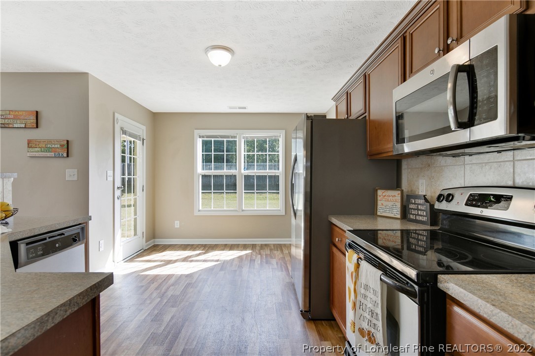 654 Hogart Street Raeford, NC 28376 - Photo 16 of 35 a kitchen with stainless steel appliances granite countertop a stove and a refrigerator
