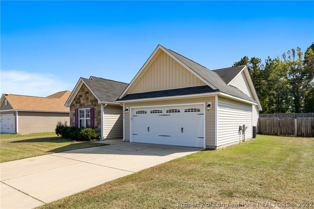 654 Hogart Street Raeford, NC 28376 - Photo 2 of 35 a view of a house with a yard and garage