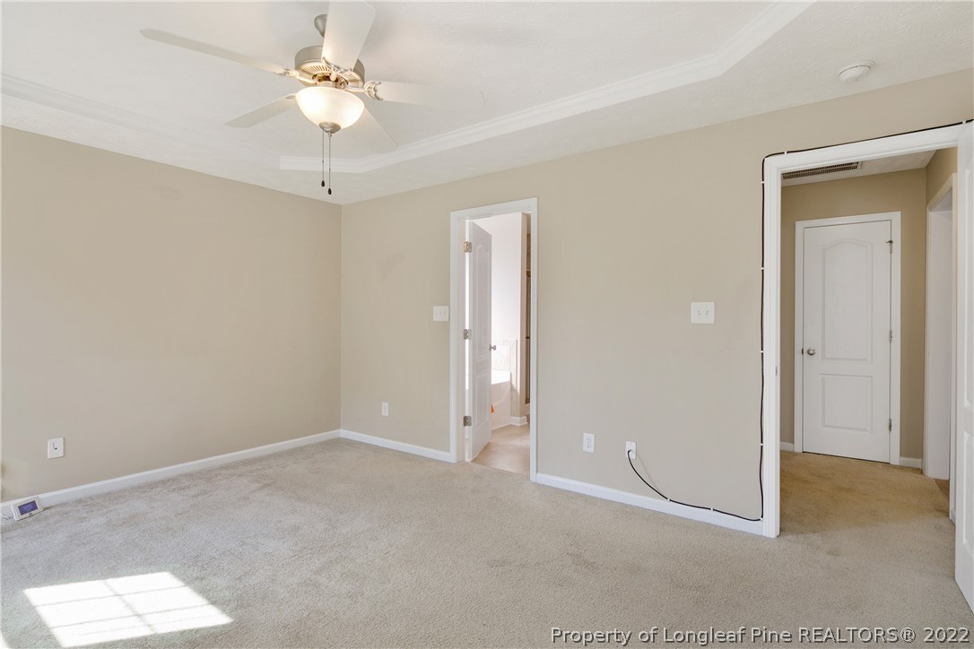 654 Hogart Street Raeford, NC 28376 - Photo 22 of 35 an empty room with a chandelier fan and windows