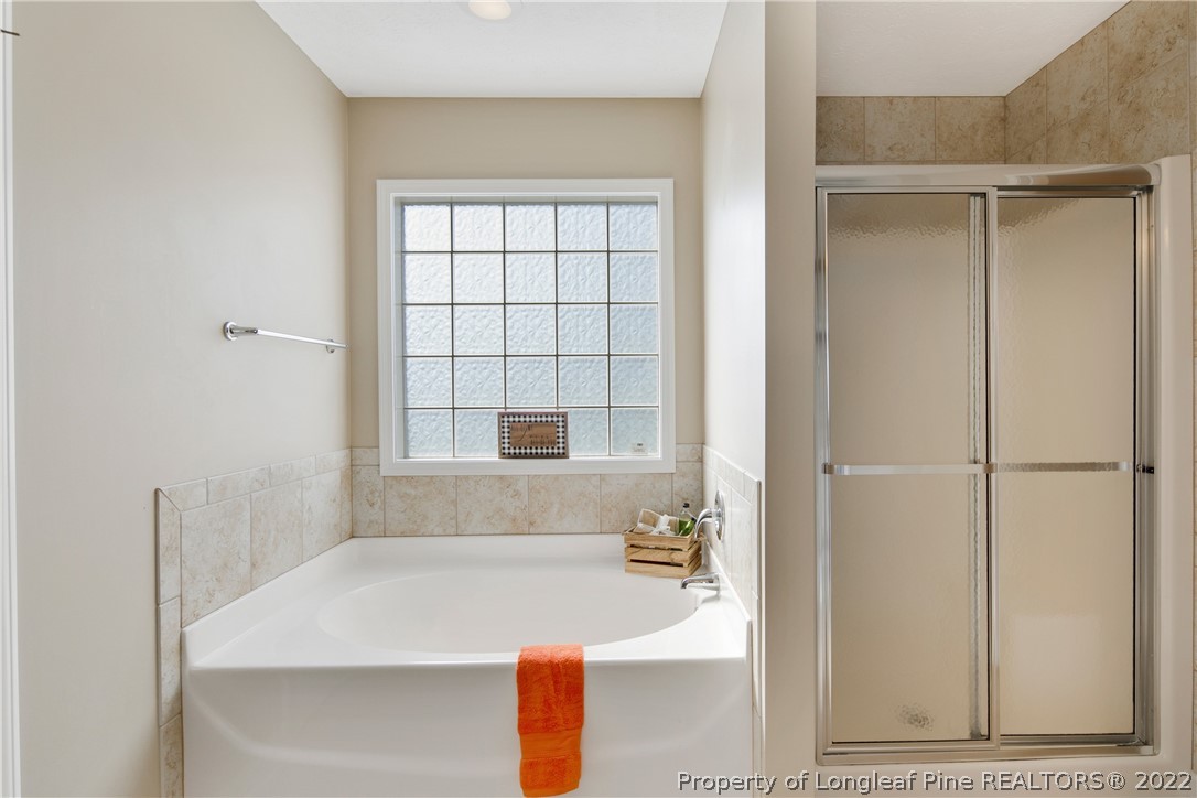 654 Hogart Street Raeford, NC 28376 - Photo 25 of 35 a bathroom with a sink a bathtub and a window