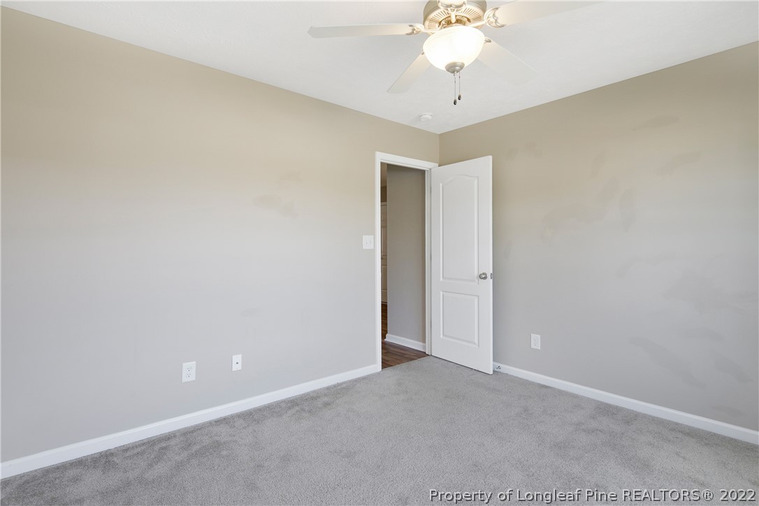 654 Hogart Street Raeford, NC 28376 - Photo 28 of 35 an empty room with a chandelier fan and a window