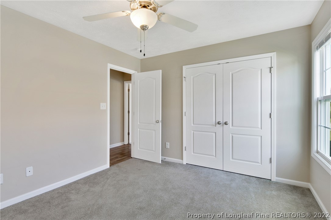 654 Hogart Street Raeford, NC 28376 - Photo 31 of 35 an empty room with a chandelier fan and closet