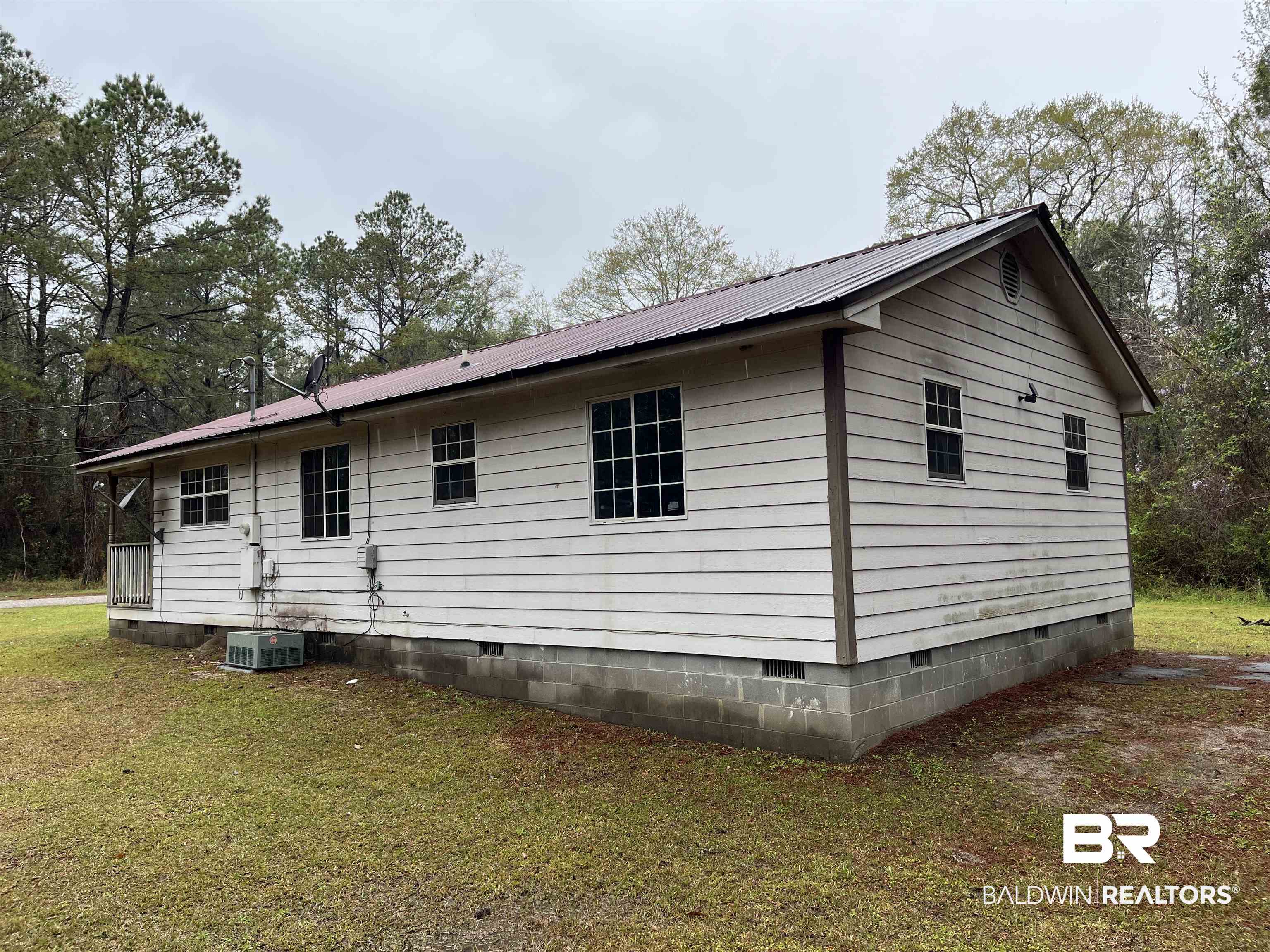127 Moore Street Brewton, AL 36426 - Photo 3 of 15 View of side of home with a lawn, crawl space, central AC unit, and metal roof