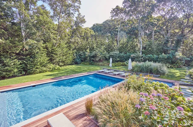 a view of a backyard with plants and a lake view