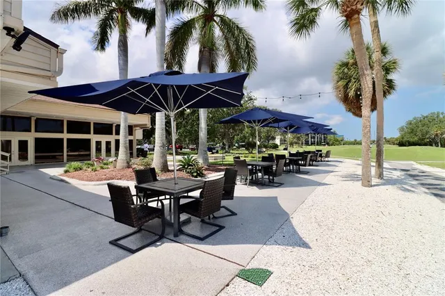 a view of a patio with a table and chairs under an umbrella
