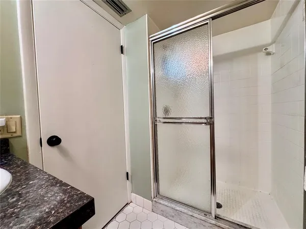 a bathroom with a granite countertop shower and a sink
