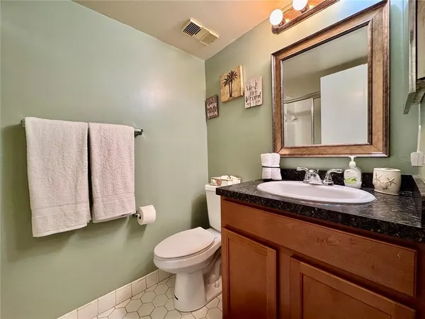 a bathroom with a granite countertop sink a mirror and a toilet