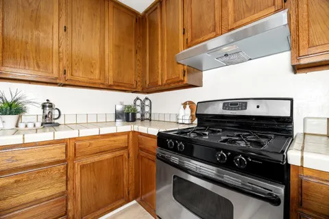 a kitchen with wooden cabinets and a stove top oven