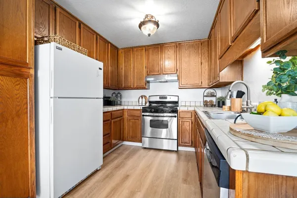 a kitchen with a refrigerator a stove top oven a sink and dishwasher