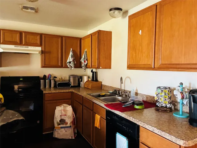 a kitchen with a stove a sink and cabinets