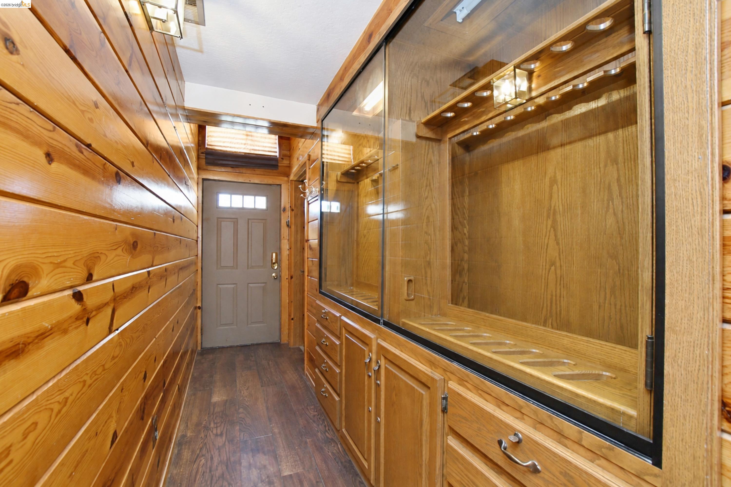 340 West Bolton Road Oakley, CA 94561 - Photo 41 of 87 Wood-paneled hallway with wood-finish flooring, a built-in display case with recessed lighting, and integrated cabinetry