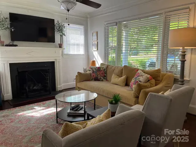 a living room with furniture a flat screen tv and a fireplace