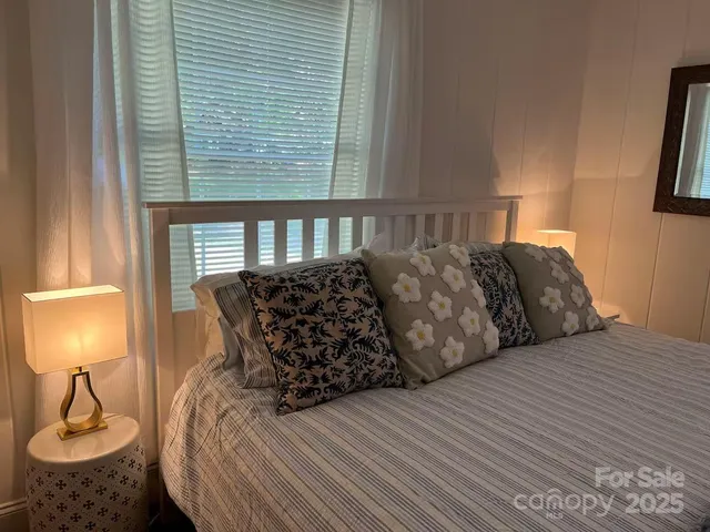 a bed sitting in a bedroom next to a window