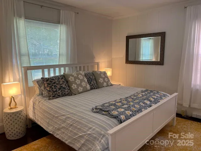 a bed sitting in a bedroom next to a window