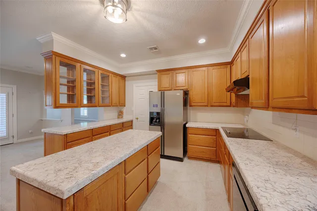 a kitchen with stainless steel appliances granite countertop wooden cabinets a oven and granite counter tops with a large window