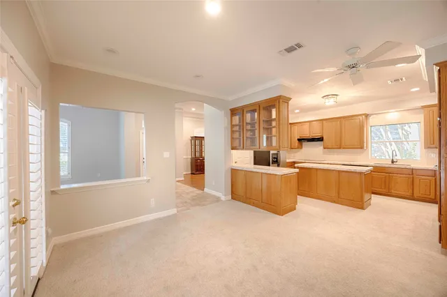 a large kitchen with kitchen island a large counter top space a sink stainless steel appliances and cabinets
