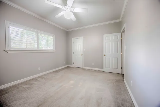 an empty room with a window and ceiling fan
