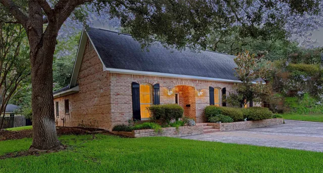 a front view of a house with a yard and green space