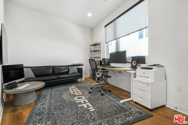 a view of a workspace with furniture and a rug