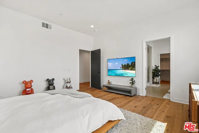 a bedroom with a bed and wooden floor