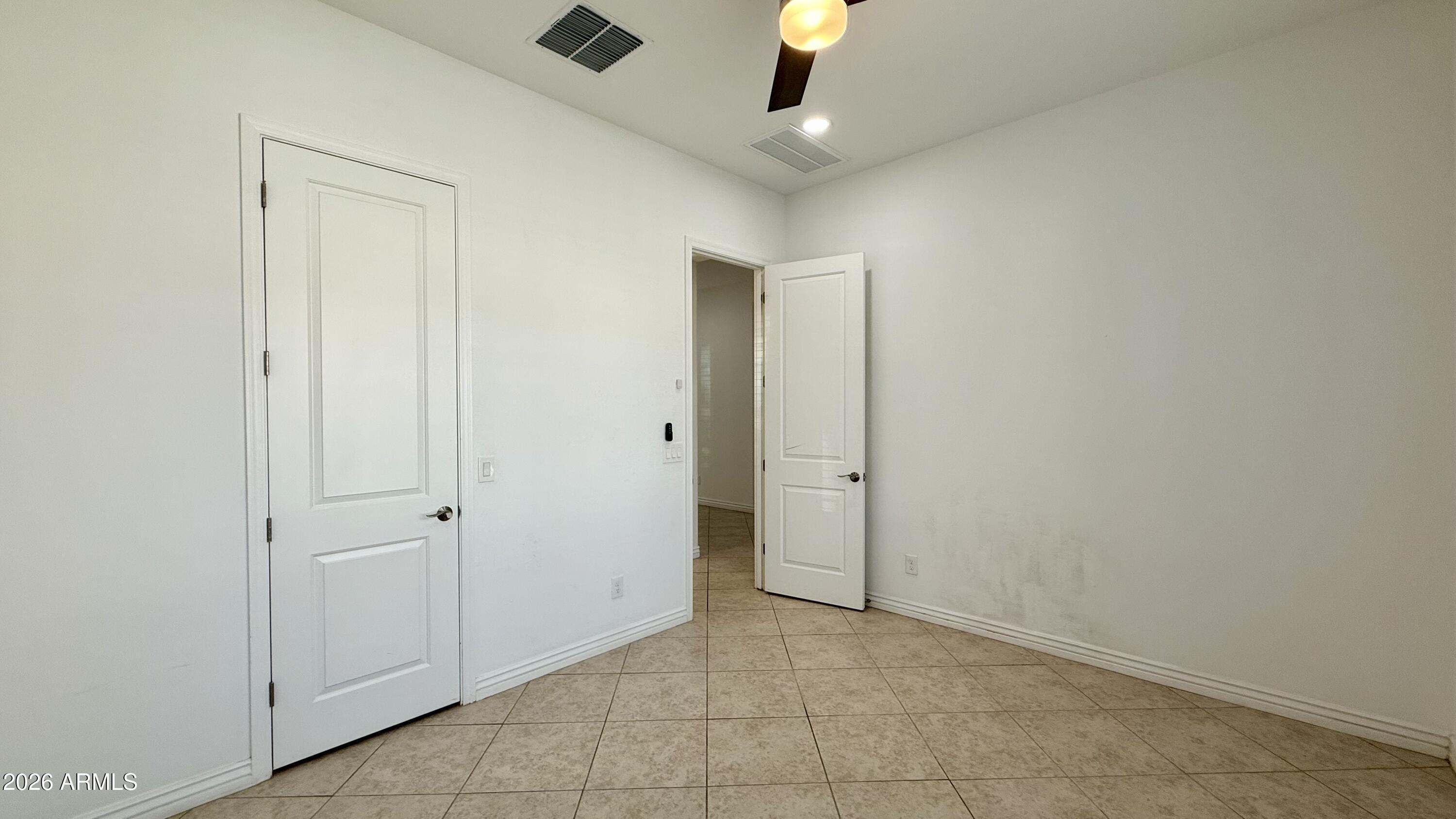 3355 East Constance Way Phoenix, AZ 85042 - Photo 15 of 42 an empty room with fan and entrance