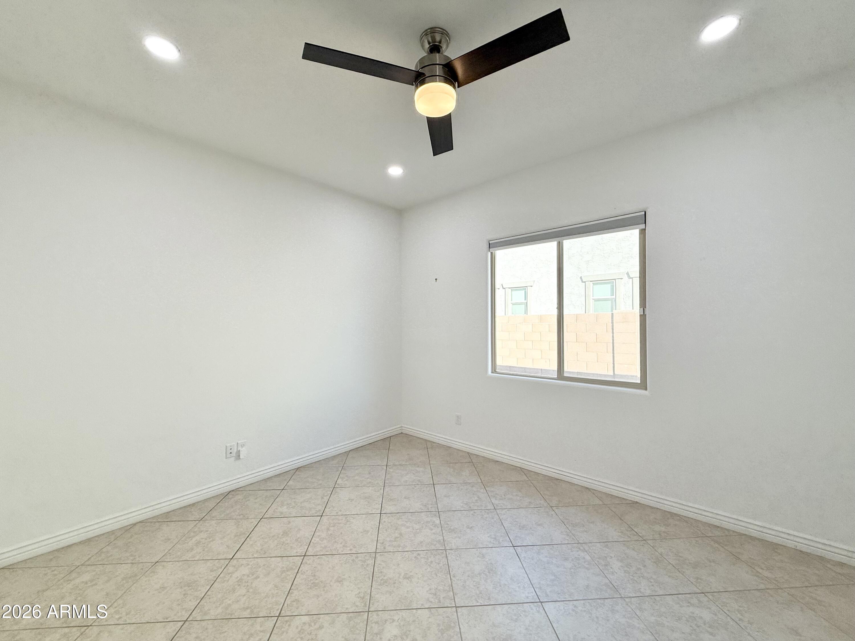 3355 East Constance Way Phoenix, AZ 85042 - Photo 19 of 42 an empty room with a window and a fan