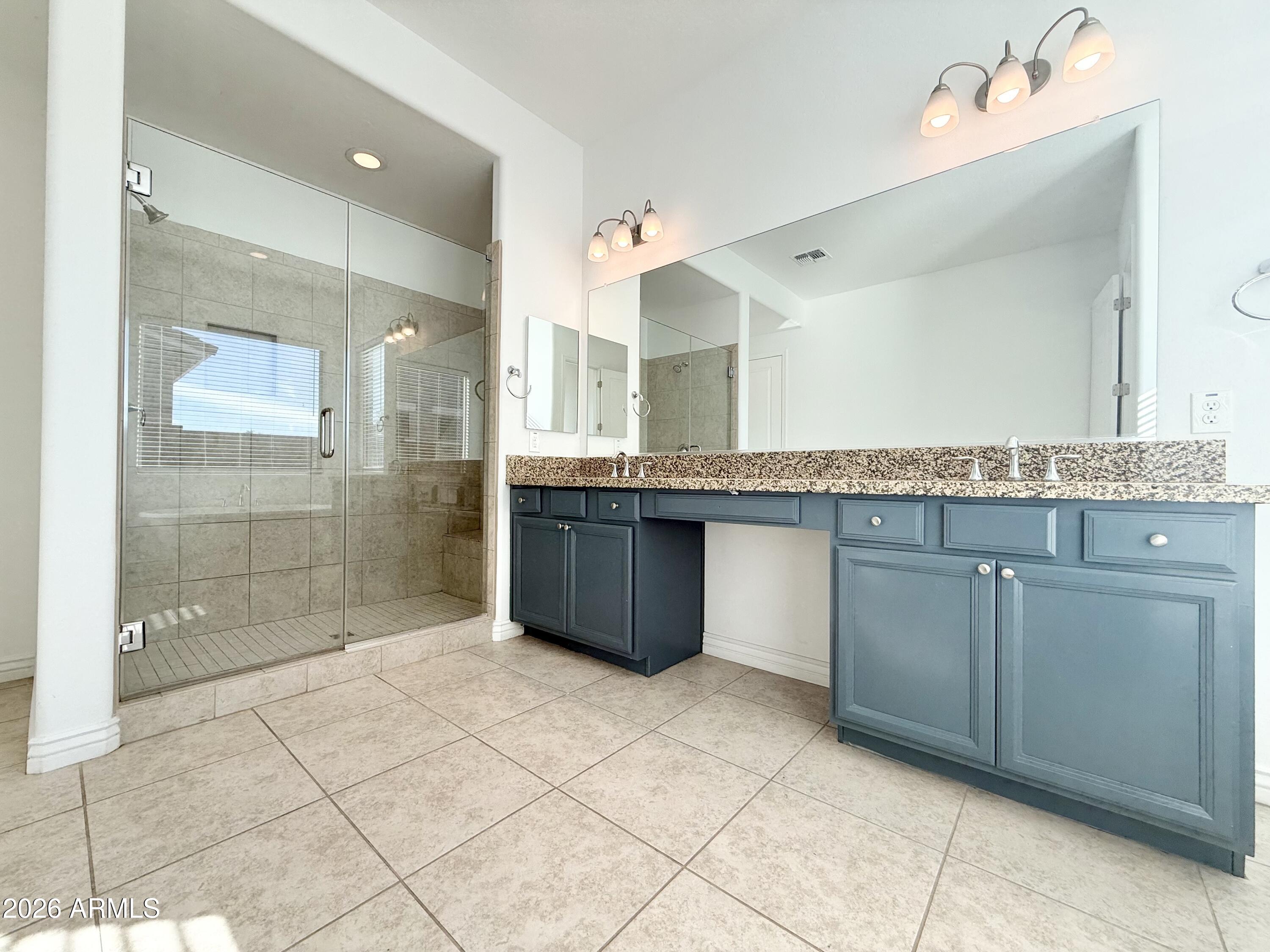3355 East Constance Way Phoenix, AZ 85042 - Photo 24 of 42 a large bathroom with a granite countertop sink a mirror and a shower