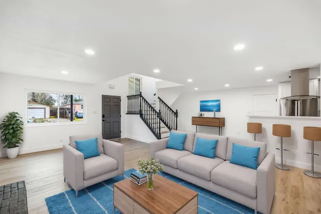 a living room with furniture a flat screen tv and a fireplace