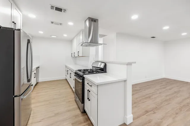 a kitchen with stainless steel appliances a refrigerator sink and stove