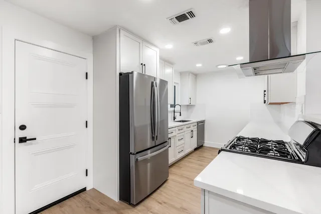 a kitchen with stainless steel appliances white cabinets and a sink