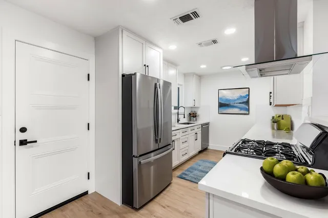 a kitchen with granite countertop white cabinets and a sink