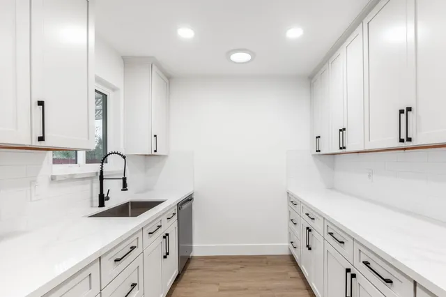 a kitchen with granite countertop a stove and a wooden floor