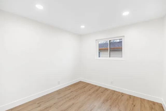 a view of an empty room with wooden floor