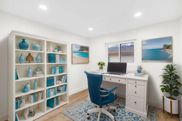 an empty room with wooden floor and window