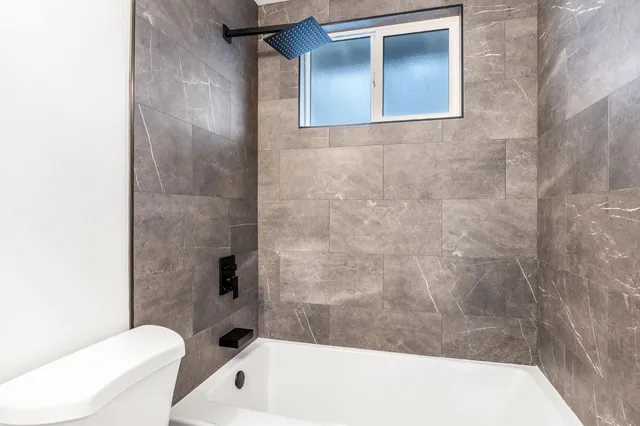 an empty room with wooden floor and a ceiling fan