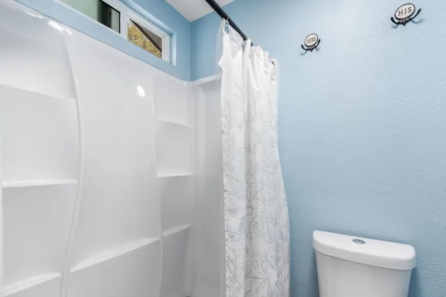 a view of a backyard with table and chairs and wooden fence