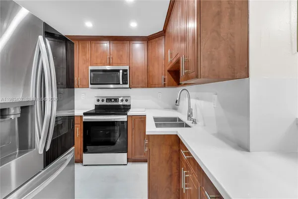 a kitchen with granite countertop stainless steel appliances and wooden cabinets