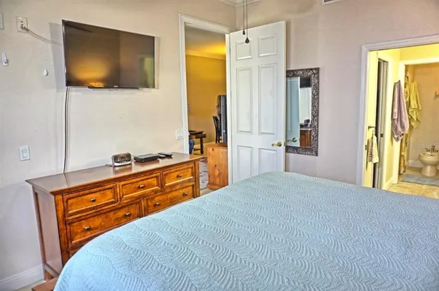 a bedroom with a flat screen tv on dresser and a flat screen tv