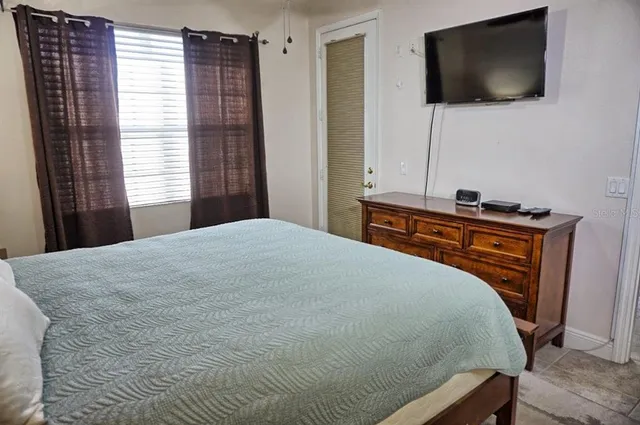 a bedroom with a bed and a flat screen tv